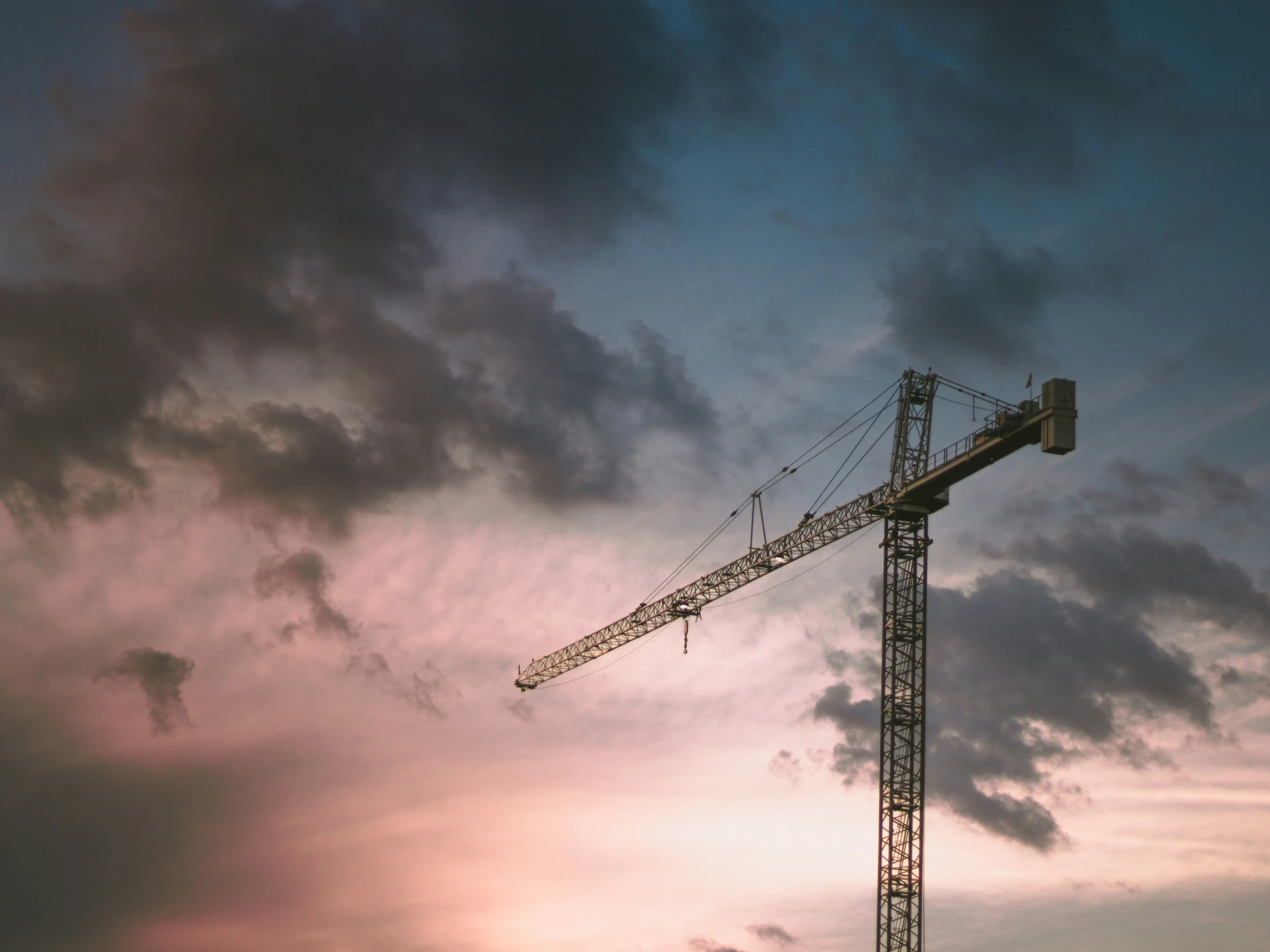 a crane is standing in the clouds while the sun is setting