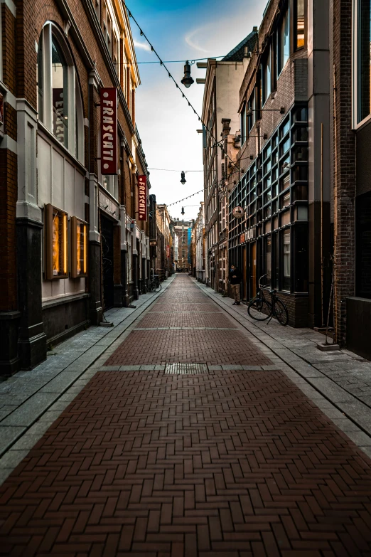 a narrow street lined with brick buildings with windows