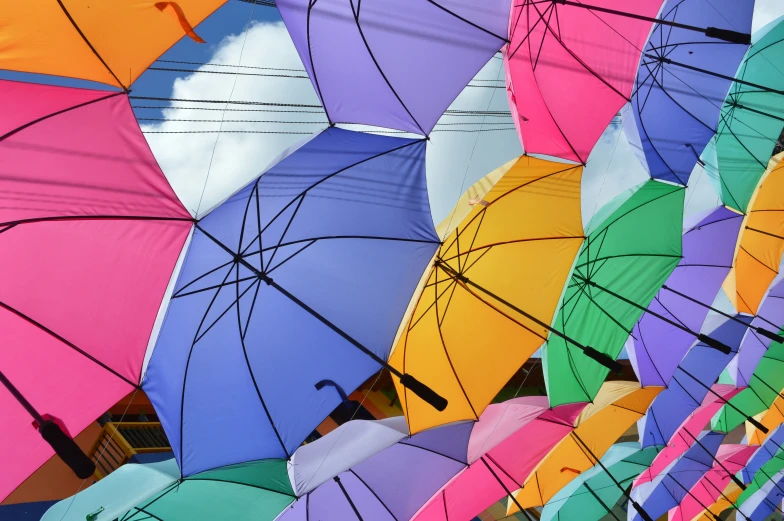 many multicolored umbrellas are on a sunny day
