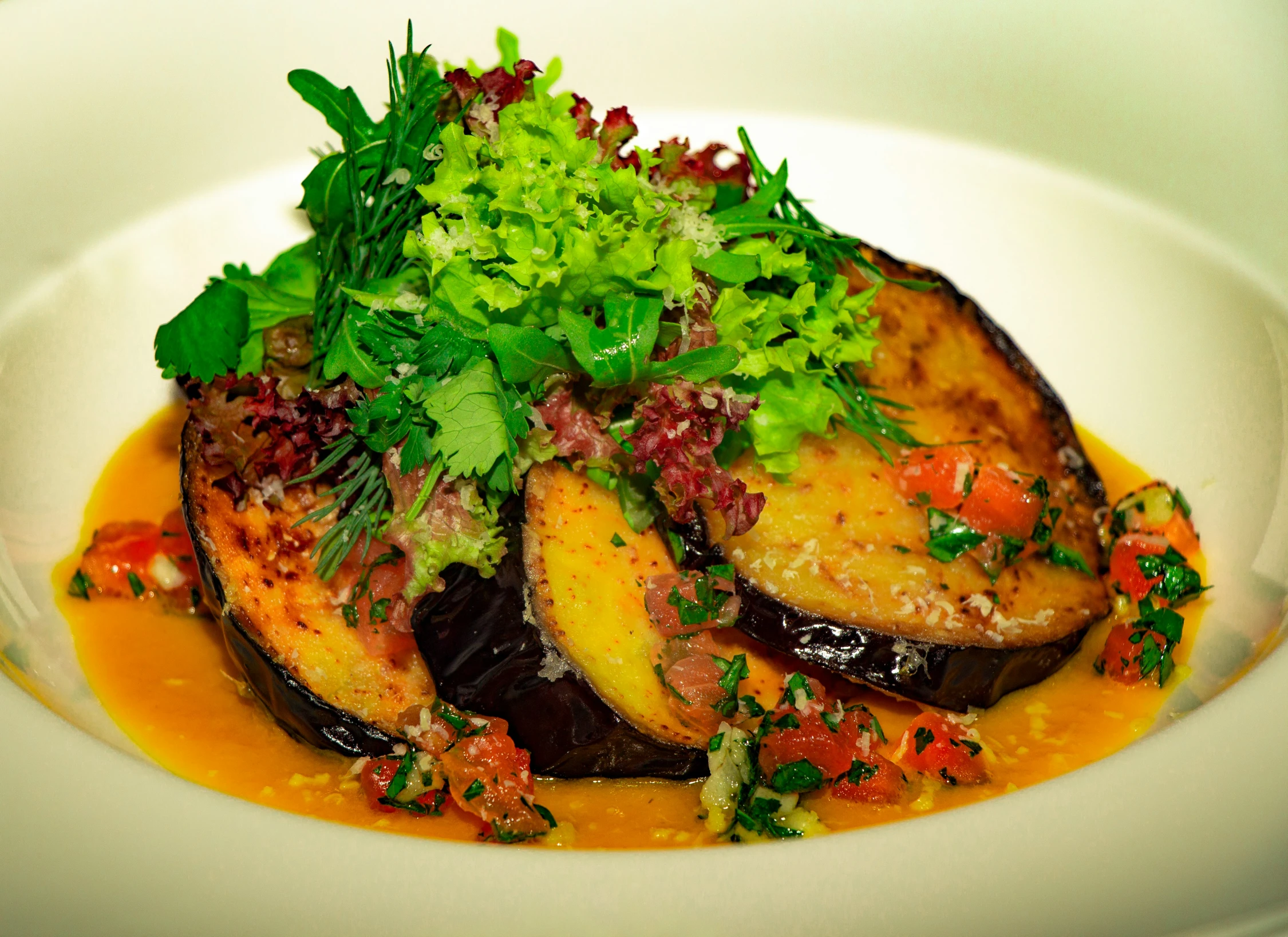 an eggplant dish with some parsley on top of it