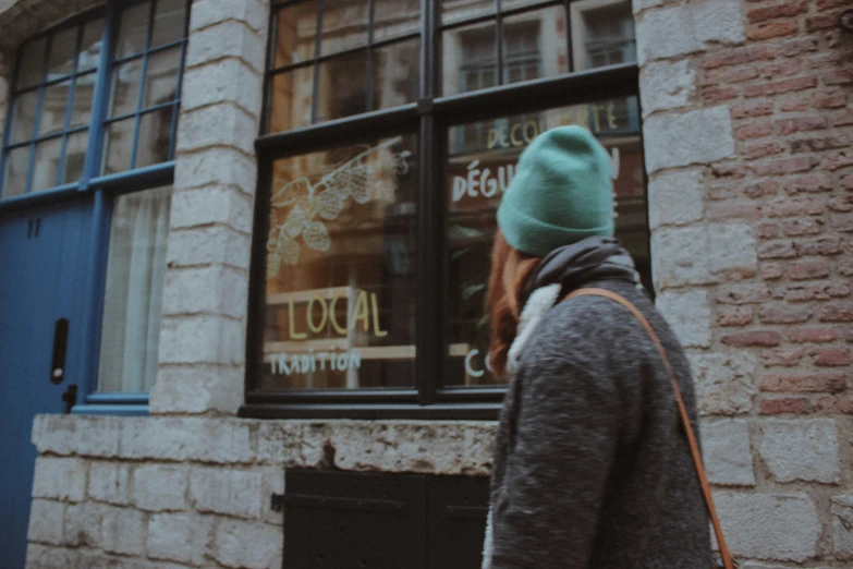 a person walking down a street past brick buildings