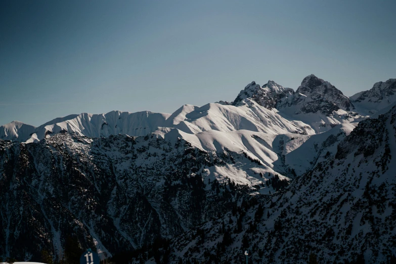 there are many snow - covered mountaintops and trees in the foreground