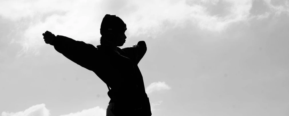 a black and white po of a man flying a kite