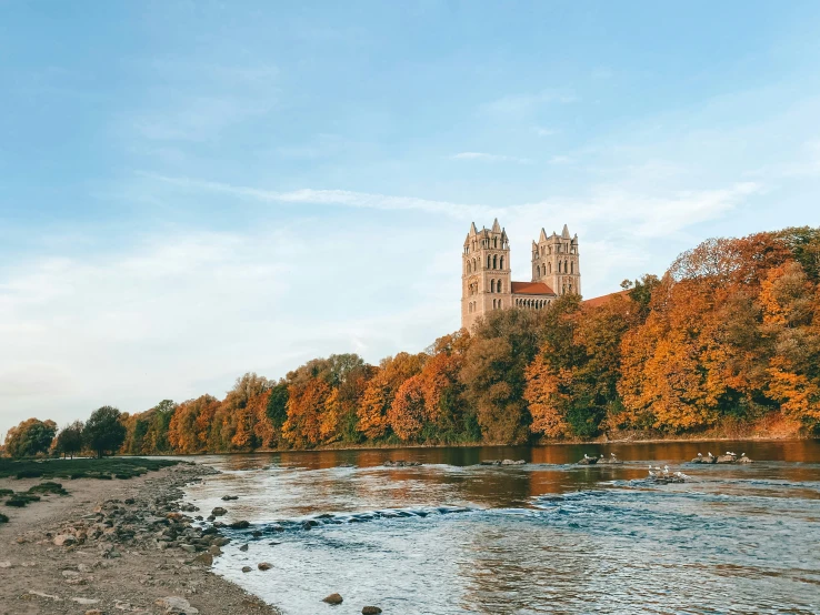 the cathedral is shown in the fall colors by the river