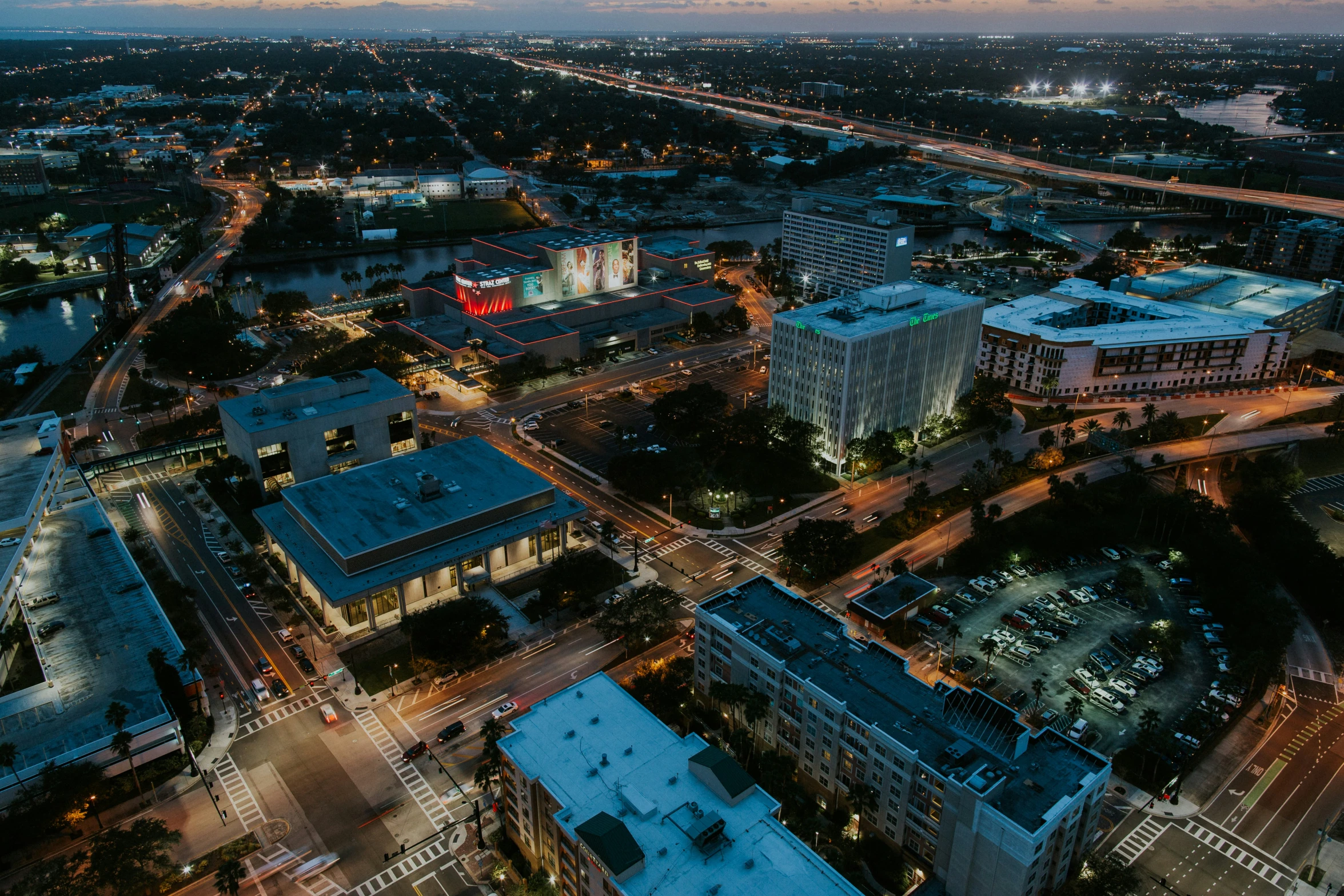 a city with several streets, buildings and lights at night