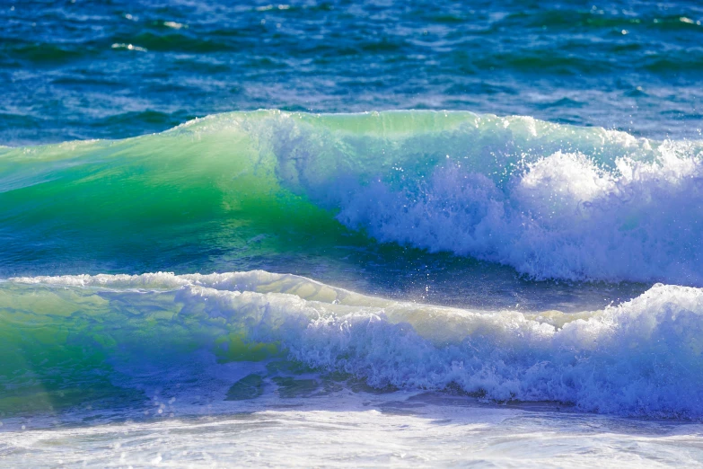 the blue ocean water is covered by an enormous wave