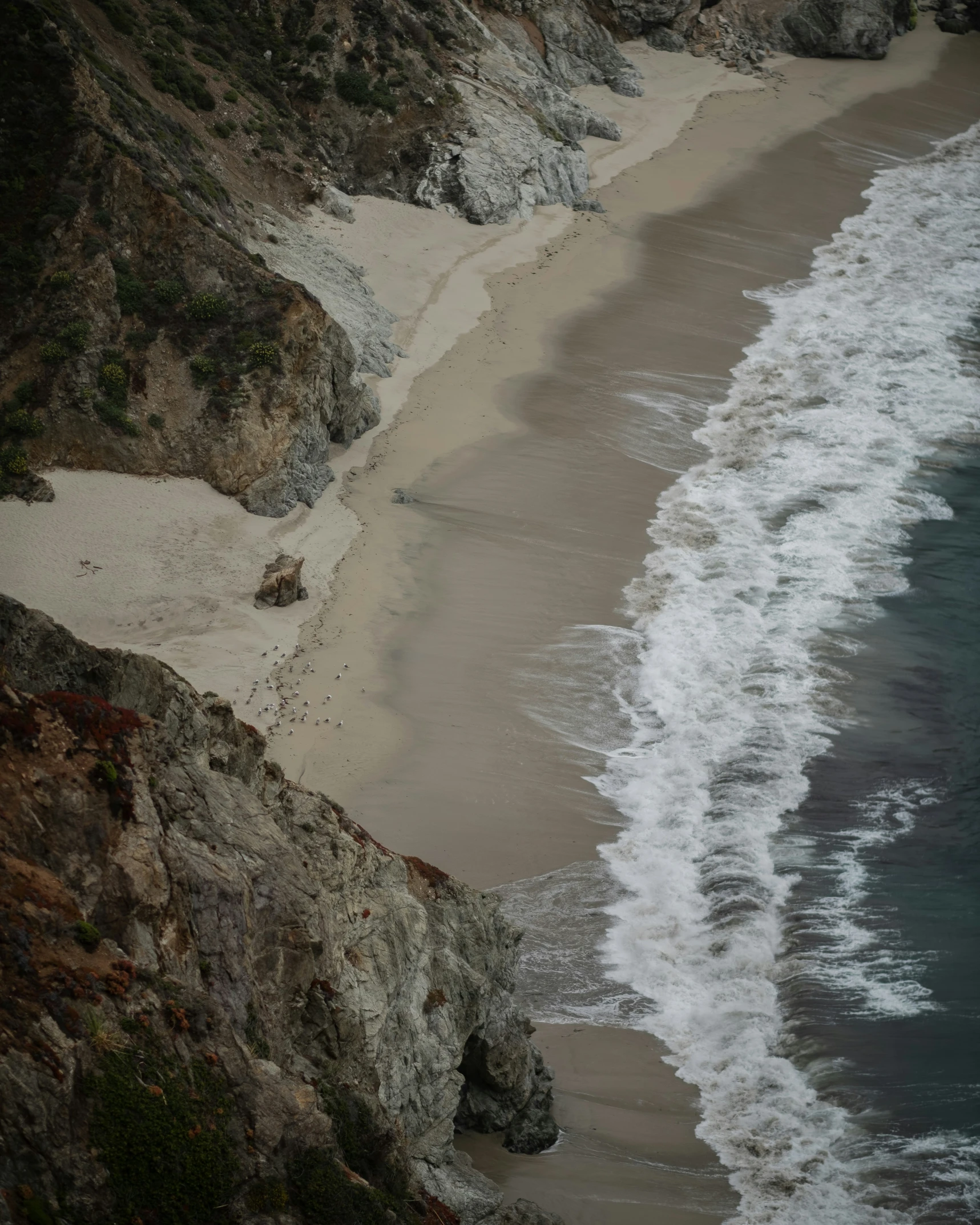 the water and sand are beside the shore of an ocean