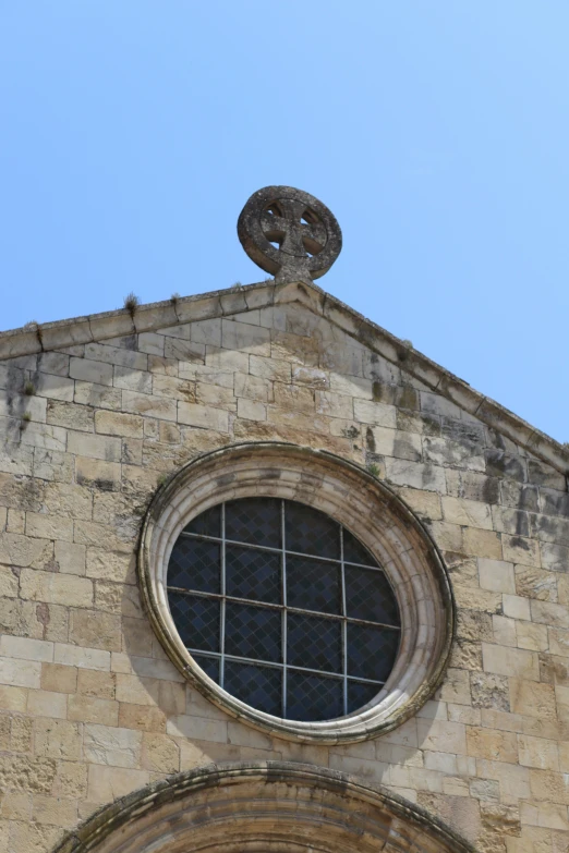 a circular window on top of a brick building