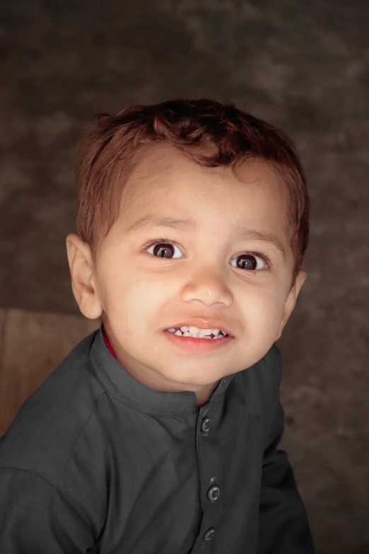 a small boy looking at the camera with a smile