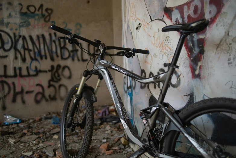 a bicycle is standing next to graffiti