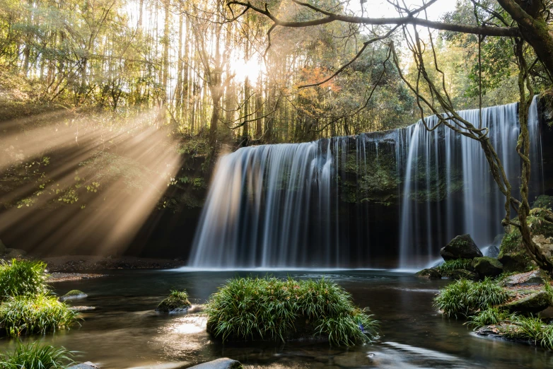 the sun is shining down over the water at a waterfall