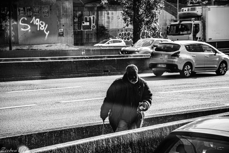 the person is walking in the rain on the sidewalk