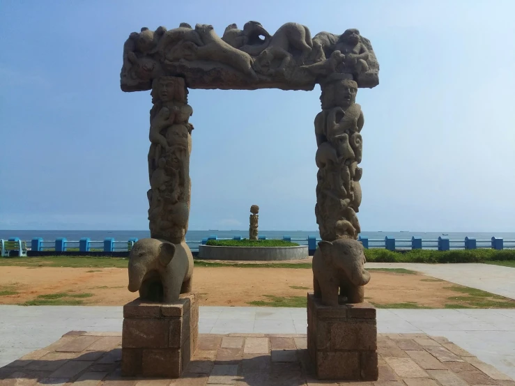 two very cute sculptures by some sand near the ocean