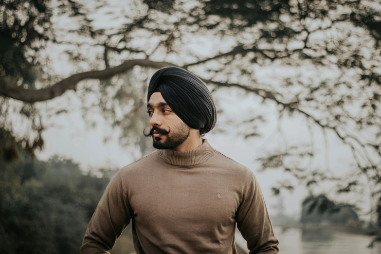 a man with a turban is walking through a field