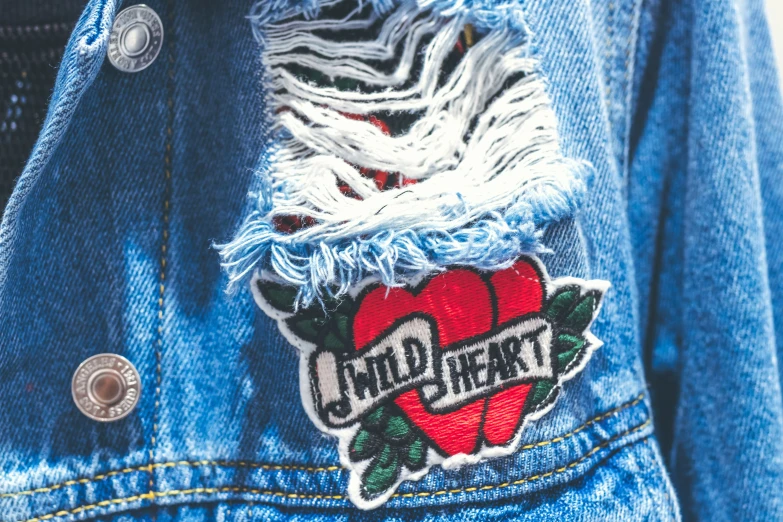 denim jacket with an apple patch and the word cold heart on it