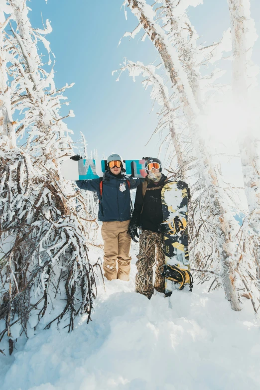 two people are holding snow boards on the top of a hill