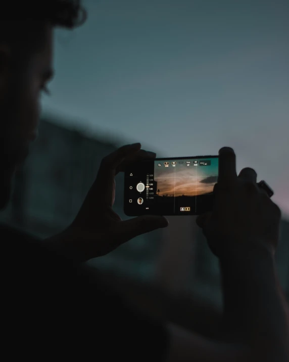 a man taking a po with his phone at night