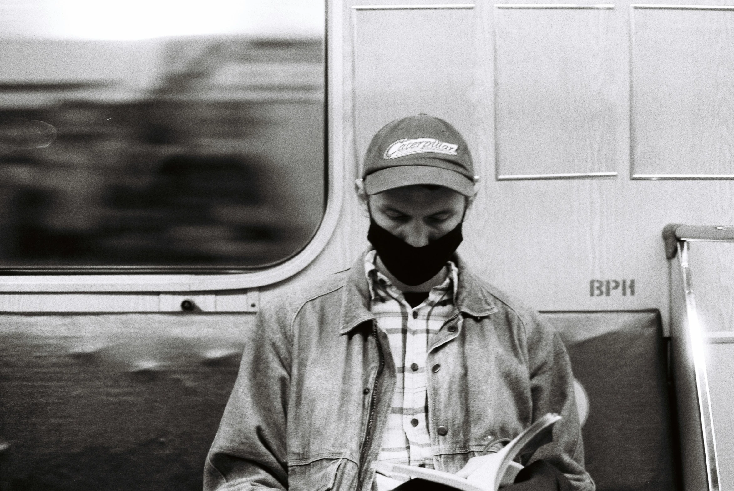 a man sitting on a train reading a book