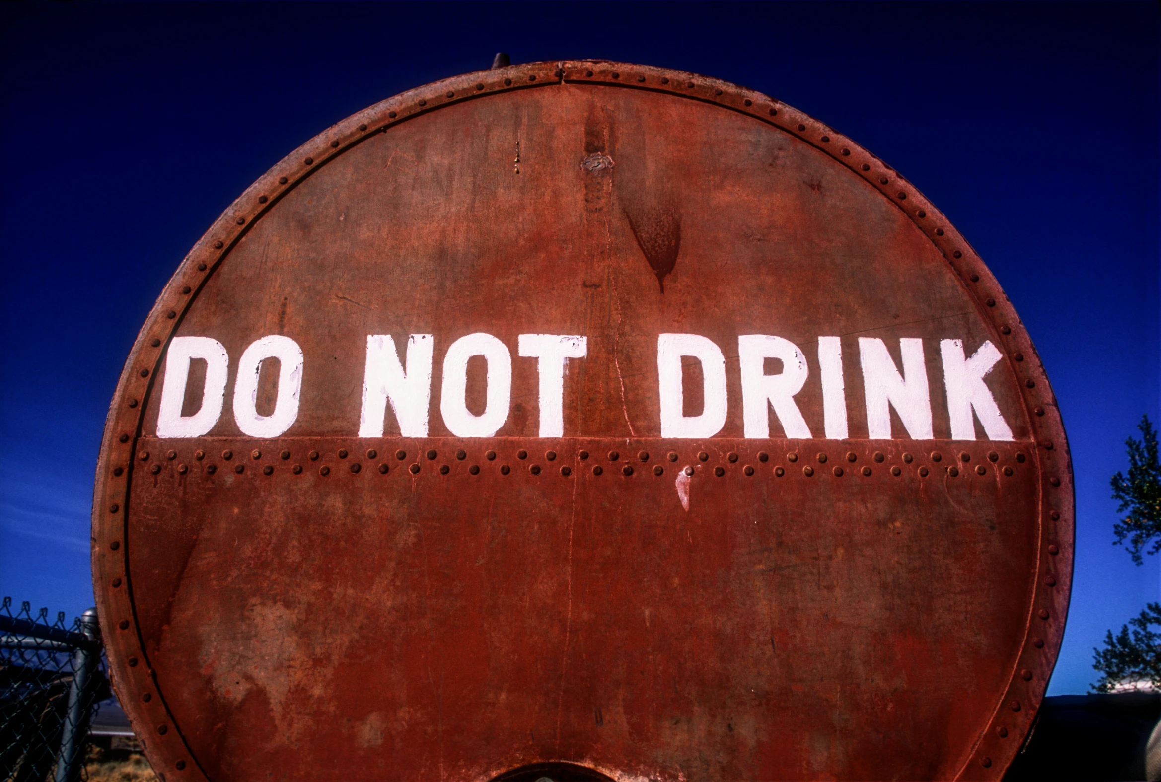 an old rusty sign that says do not drink