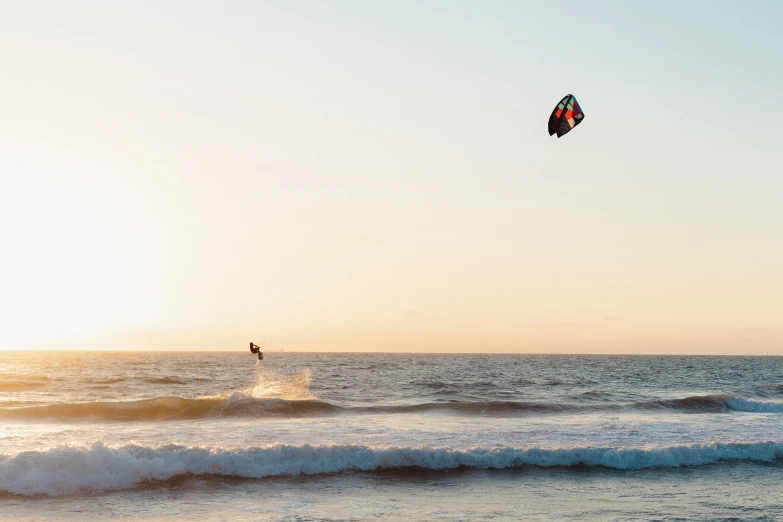 man windsurfing over rough ocean waves on sunny day