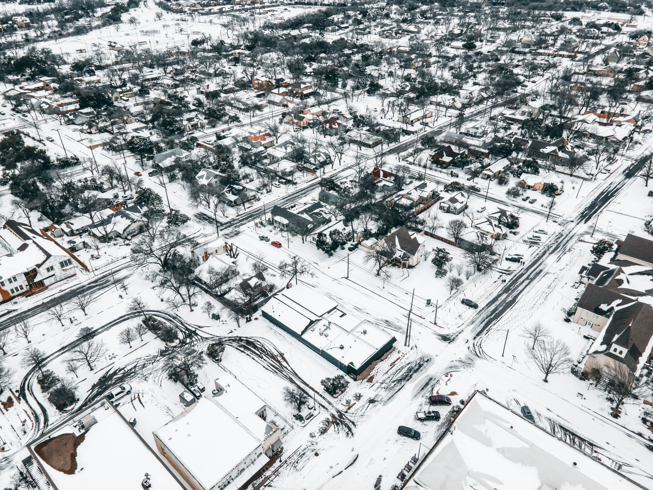 an aerial view of an intersection with snow in winter