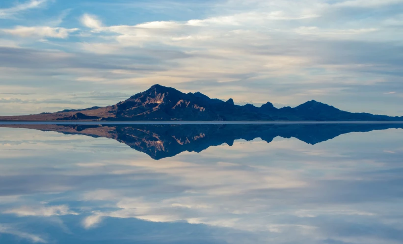 a mountain is reflected in the still water of a lake