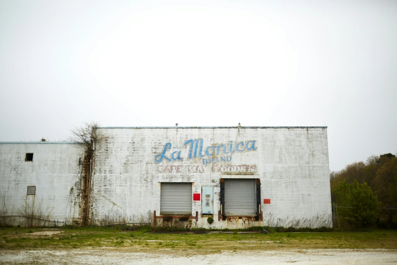 an old white building with two garage doors