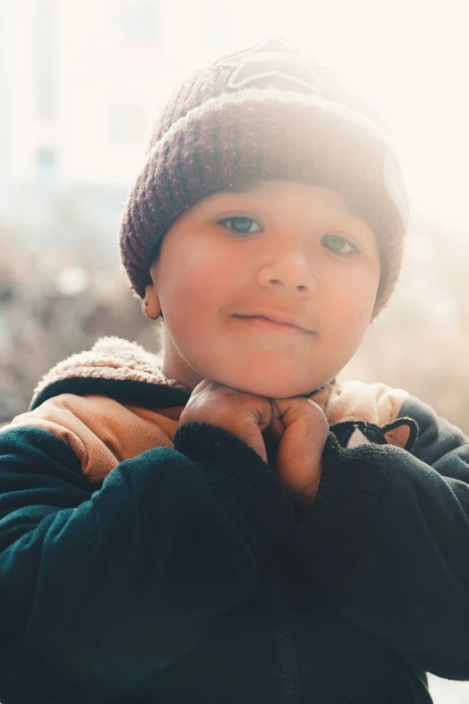 a child in a brown hat is posing for a po