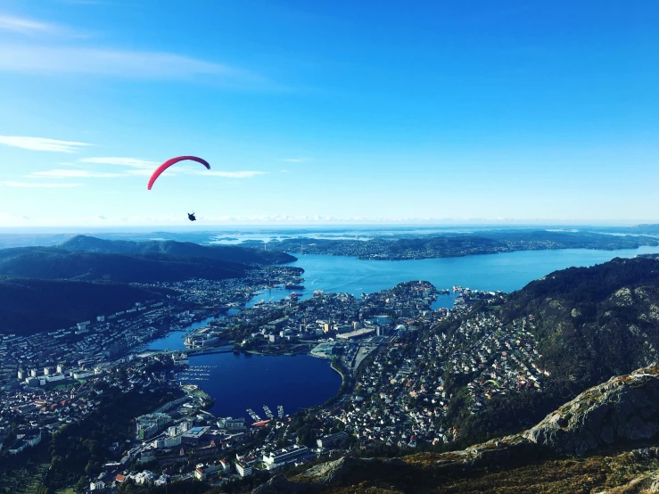 two parasailers on a clear day above a large town