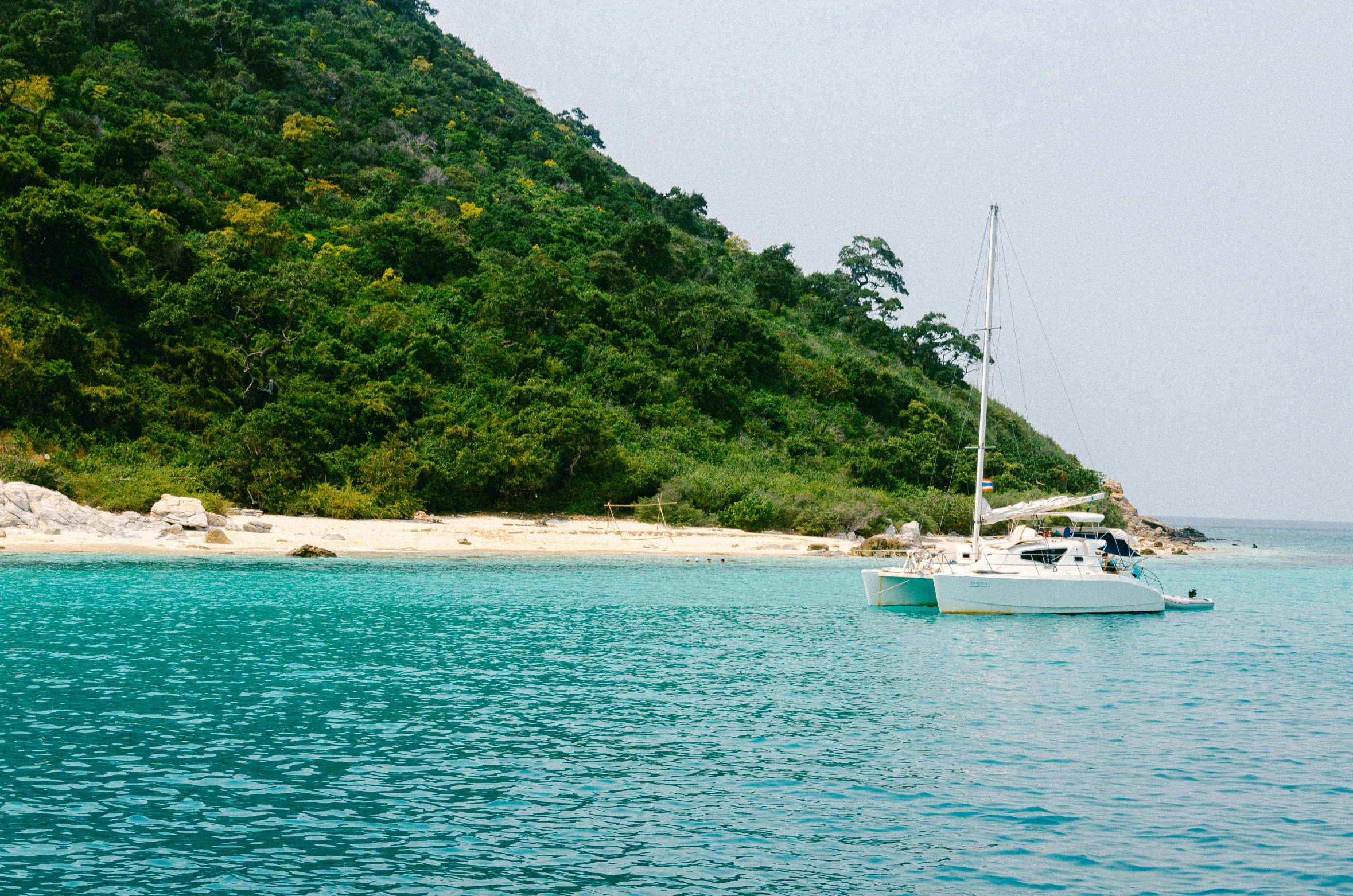 a white boat is in the ocean with blue water