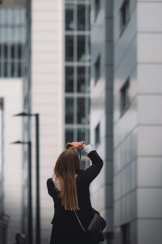 a woman standing on the sidewalk taking a picture