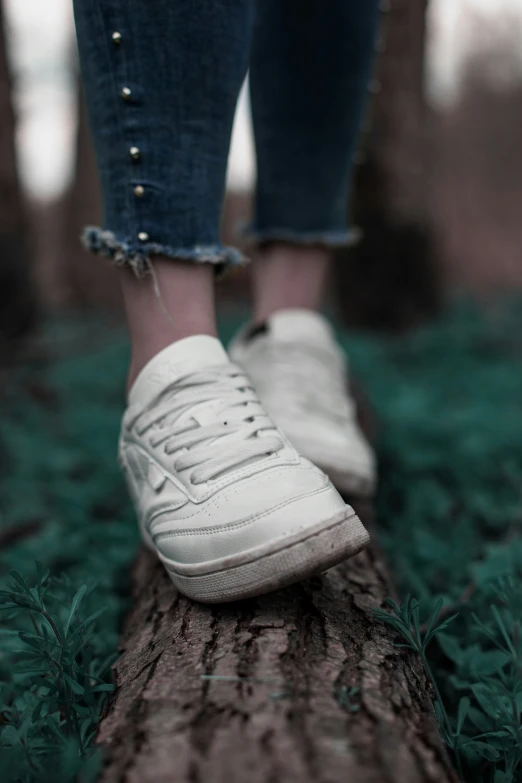 a close - up po of a person's shoes on a log