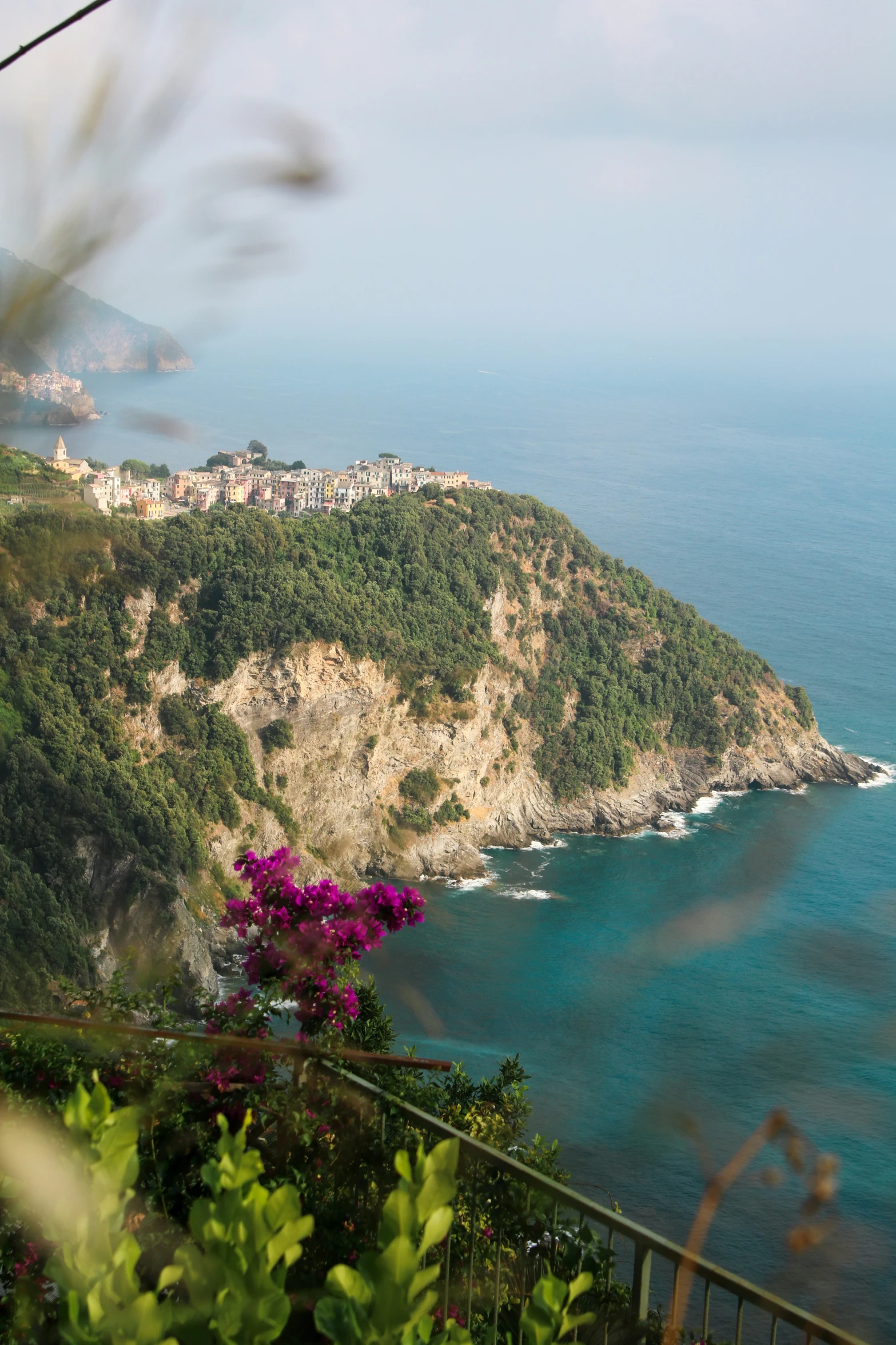 the view of a town is on the top of a hill by the ocean