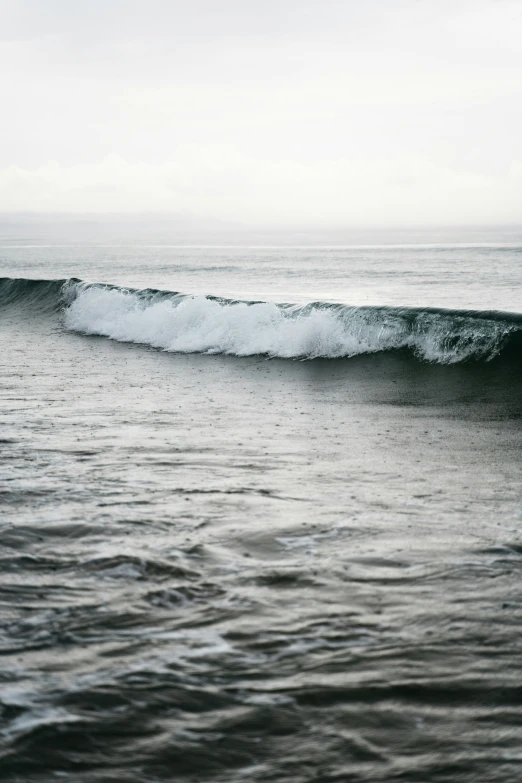 a large wave crashing over a beach in the ocean