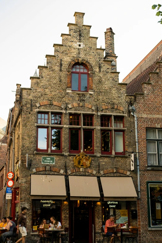 an old brick building has two awnings and a clock