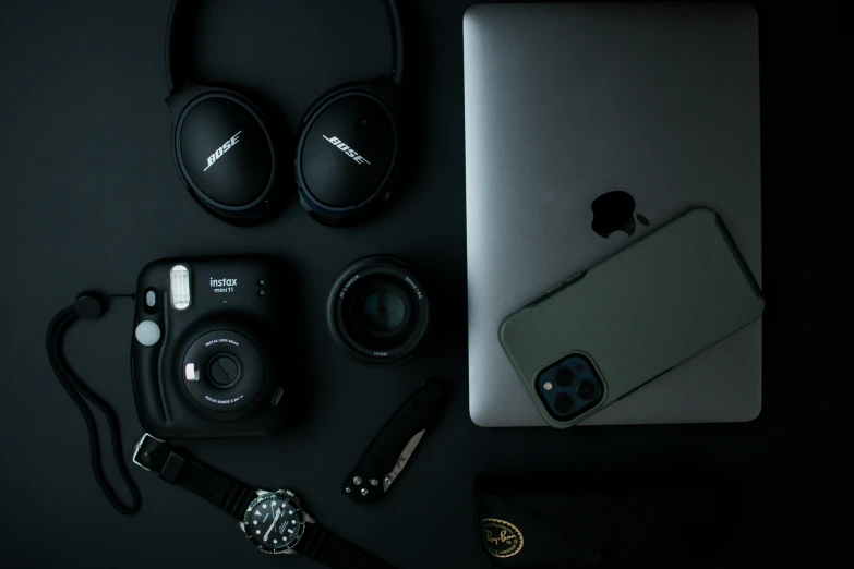 a macbook air with a pair of headphones and a wallet