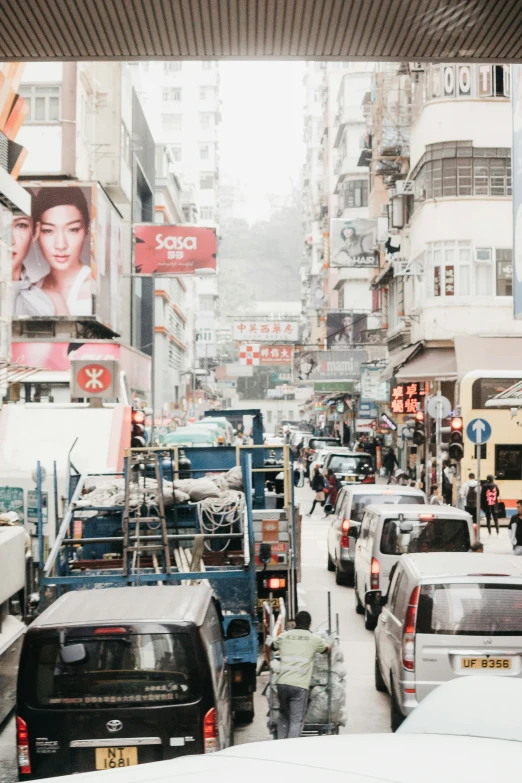 a busy city street with heavy snow, traffic and advertising signs