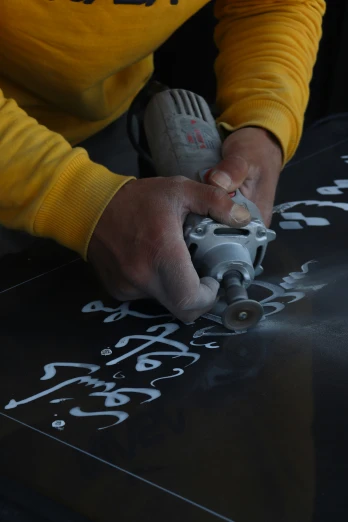 the mechanic uses an electric tool to sand up the surface