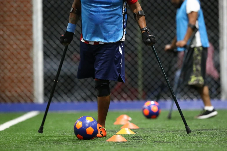 a male soccer player holding stick and ball