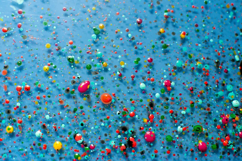 some beads are on a blue surface next to oranges and limes