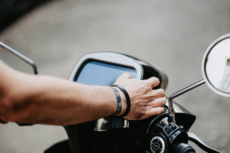 a man with his hand on the handlebars of a motorcycle