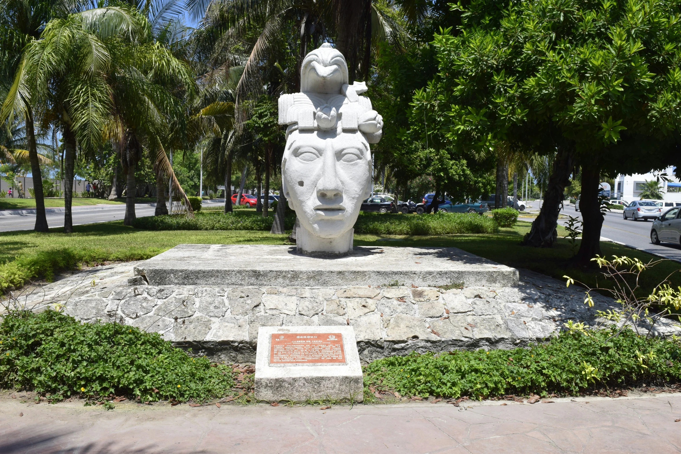 a stone statue of a lion surrounded by palm trees