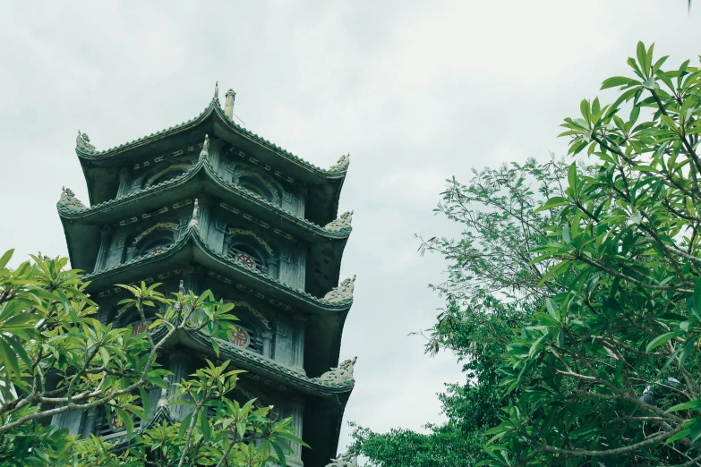 a tall building with a clock and green trees