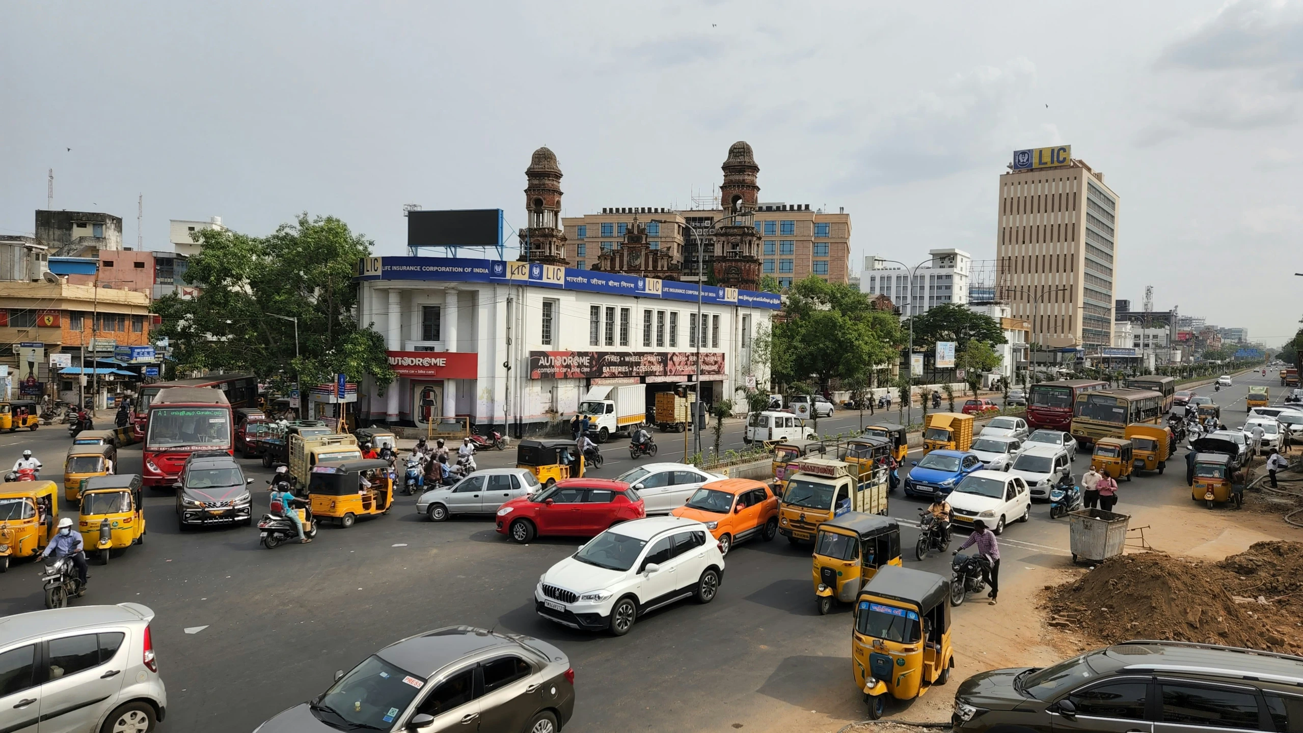 cars driving down the road near many buildings