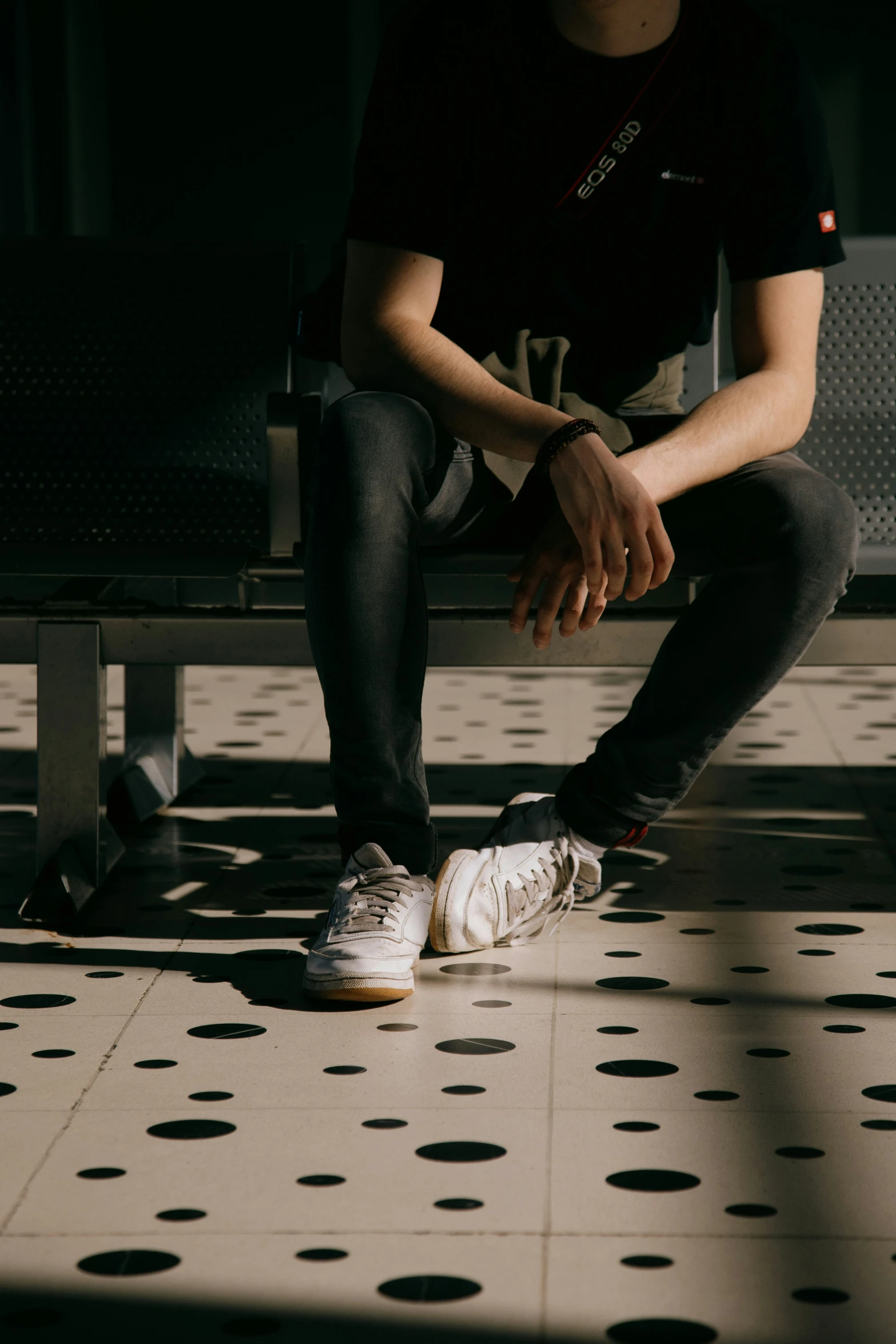 a man sitting on a bench next to a polka dot floor