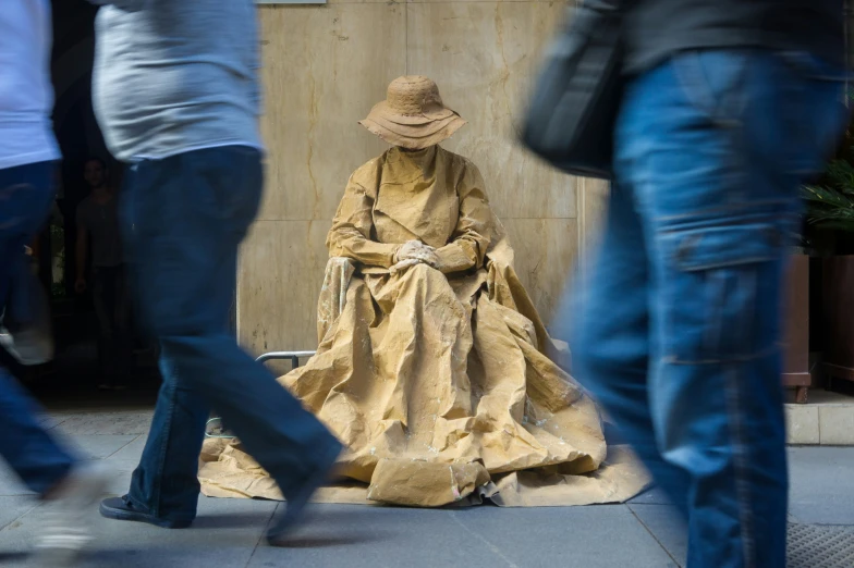a statue sitting on the sidewalk next to a group of people