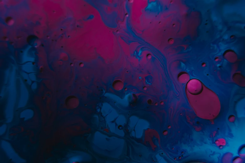 water and red bubbles are on the surface of a purple liquid