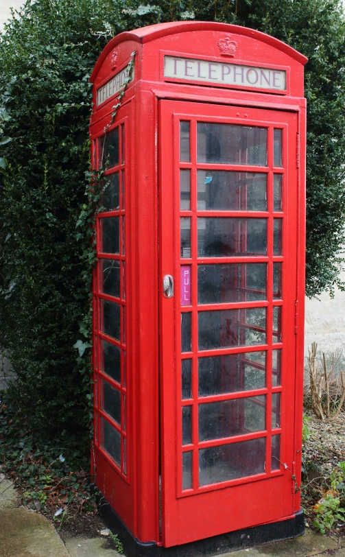 a red telephone booth that has its door open