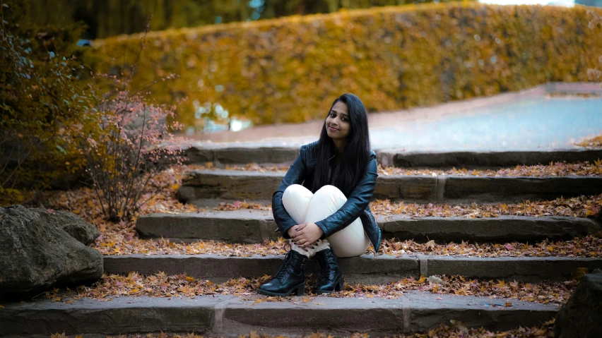 a woman sitting on steps holding a heart balloon