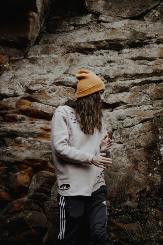 a person standing in front of a rock wall